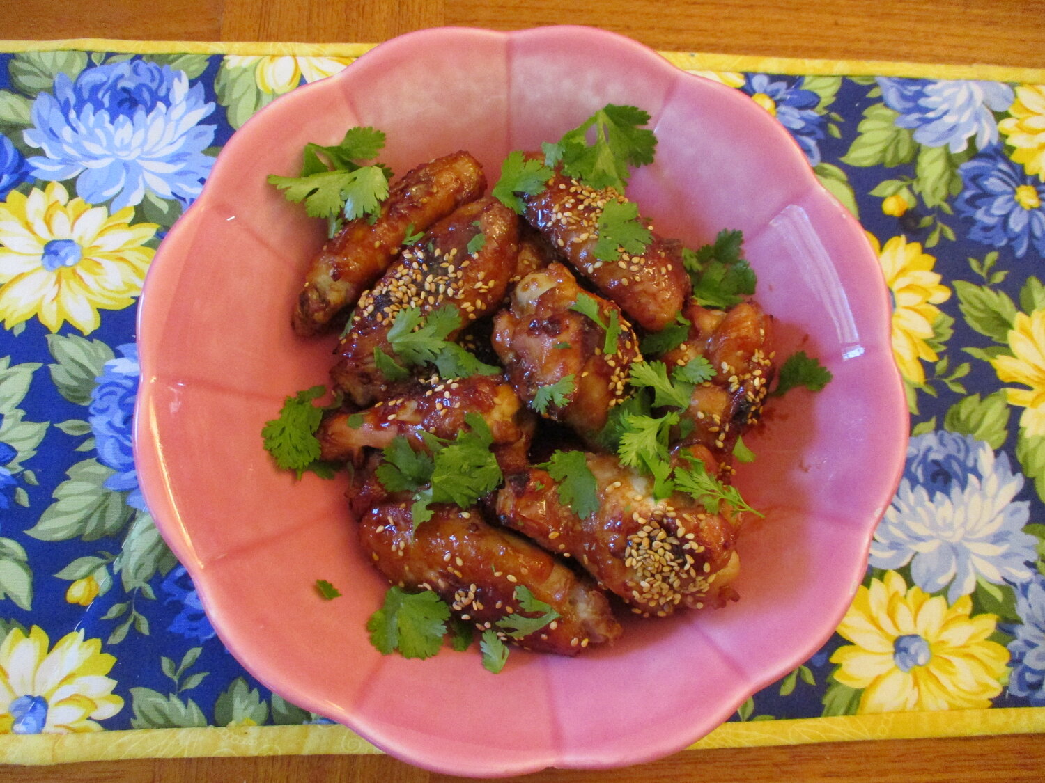 Asian chicken wings, garnished with sesame seeds and cilantro